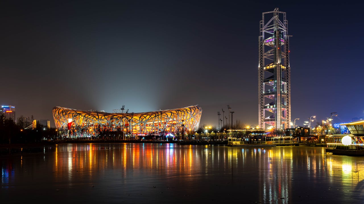 Stunning night shot of Beijing's Bird's Nest, reflecting vibrant city lights.